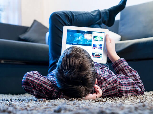 Тинейджер играет в игру на планшете